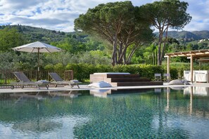 A clear swimming pool with lounge chairs and a pergola, surrounded by lush greenery and hills. - Villa in Colle Di Buggiano with 6 bedrooms sleeps 12 (Colle Di Buggiano)