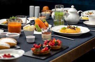 Un ricco buffet per la colazione con frutta, dolci e bevande.
