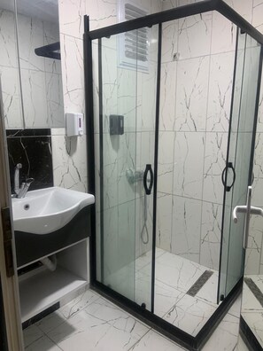 Een douche, handdoeken, zeep, shampoo