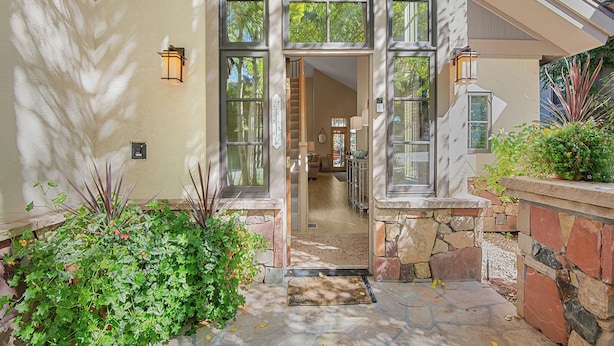 A house entrance with a stone pathway, a wooden door, and a view into the interior. - Beaver Creek Enclave | 5BR Home, Summer AC, Hot Tub (Beaver Creek)