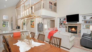 A spacious living area with a dining table, sofa, and fireplace. - Beaver Creek Enclave | 5BR Home, Summer AC, Hot Tub (Beaver Creek)