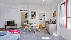 A compact living space with a dining area, kitchenette, and a TV. - Yellow Suite a Recco by Wonderful Italy (Recco)