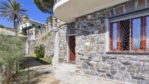 A stone building with a wooden door and a window with decorative metal bars. - Yellow Suite a Recco by Wonderful Italy (Recco)