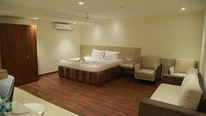 Een hotelkamer met een bed, een slaapbank, een stoel, een bureau en een kledingkast.