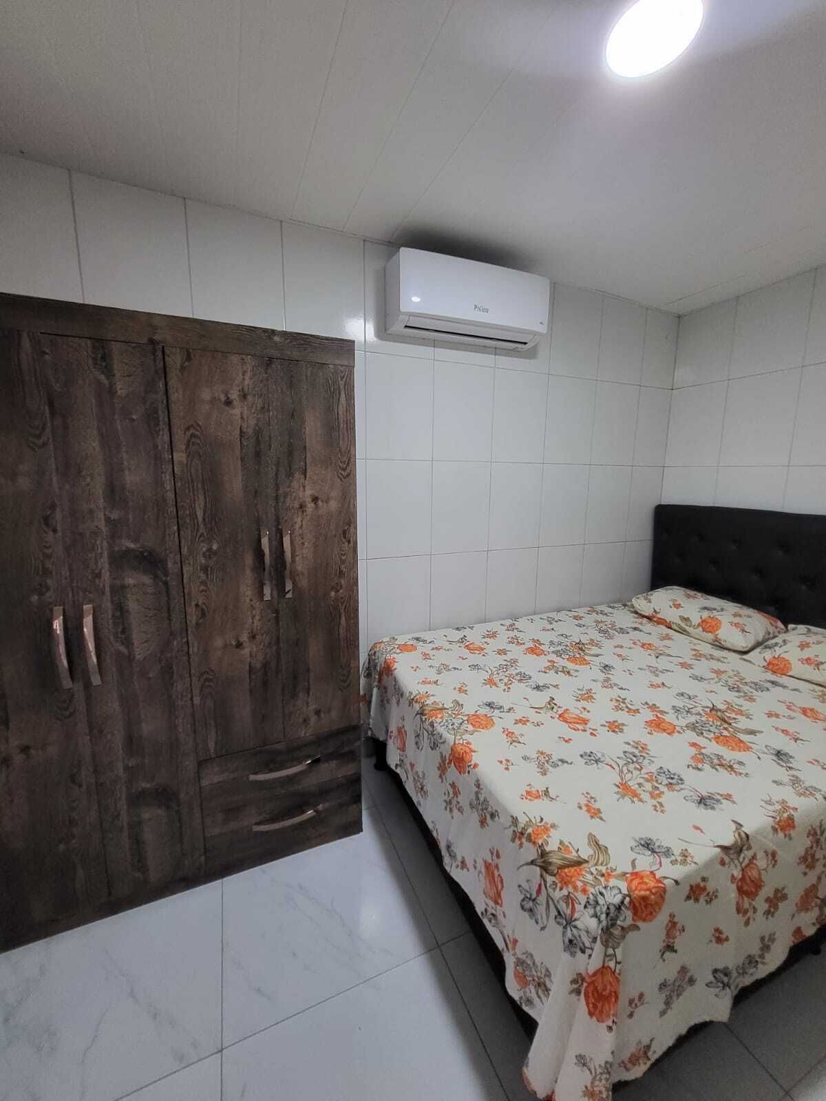 Een slaapkamer met een bed, een kledingkast en een airconditioning.