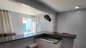 Una cocina moderna con protector contra salpicaduras de mármol, un refrigerador empotrado y un taburete pequeño.