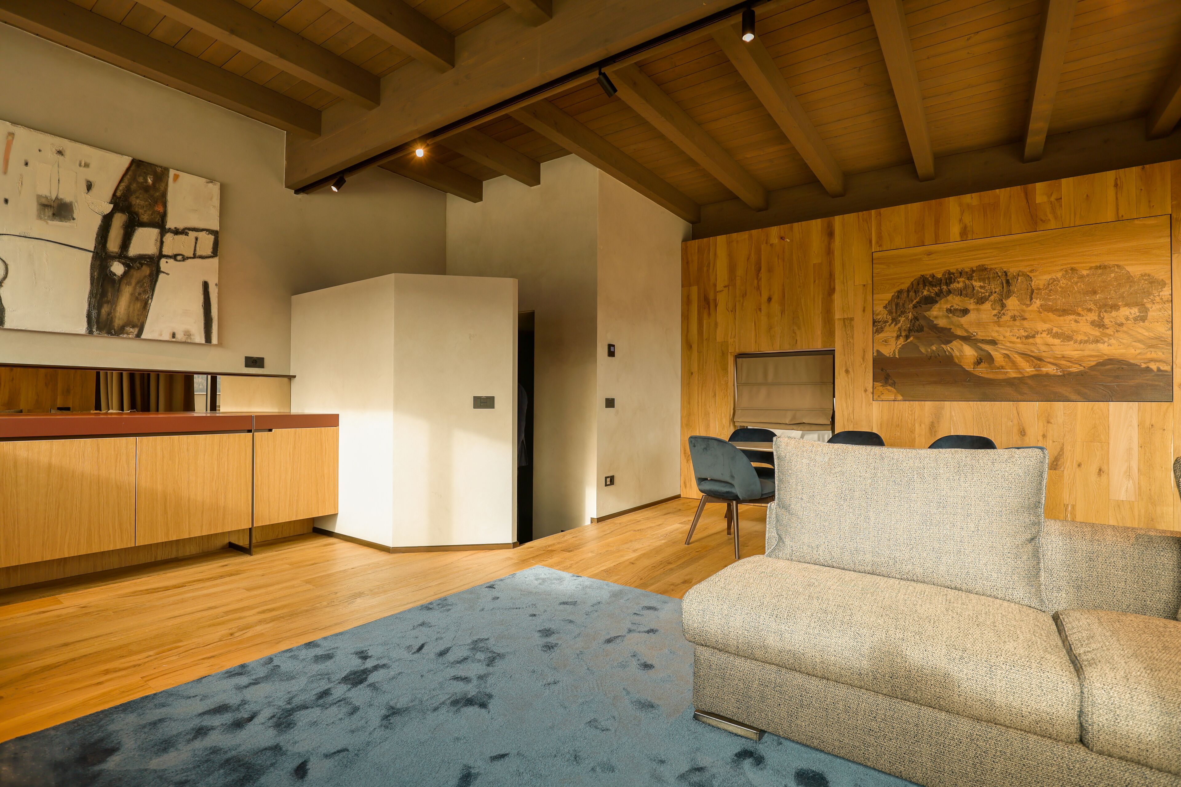 Una cocina moderna con armarios de madera, un refrigerador blanco y una zona de comedor con mesa y sillas.