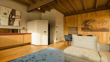 Una cocina moderna con armarios de madera, un refrigerador blanco y una zona de comedor con mesa y sillas.