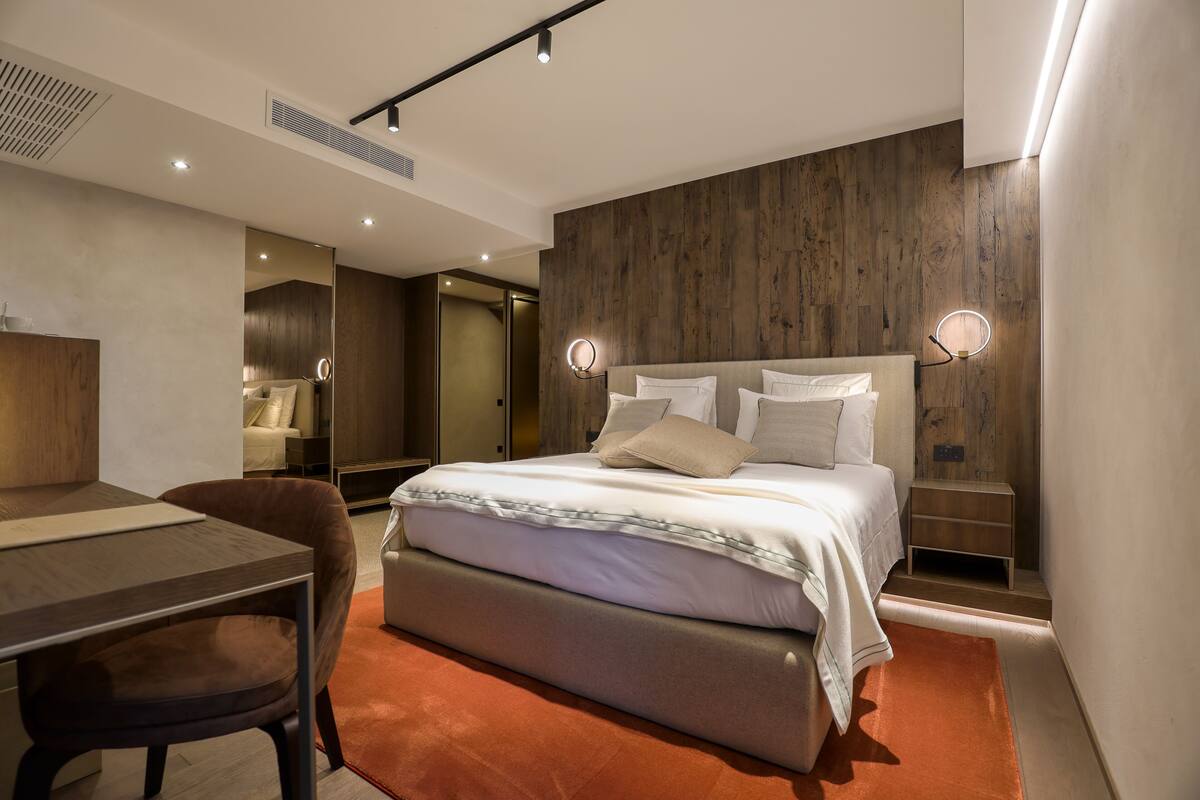 Habitació d'hotel moderna amb un llit gran, una taula de treball i una cadira.