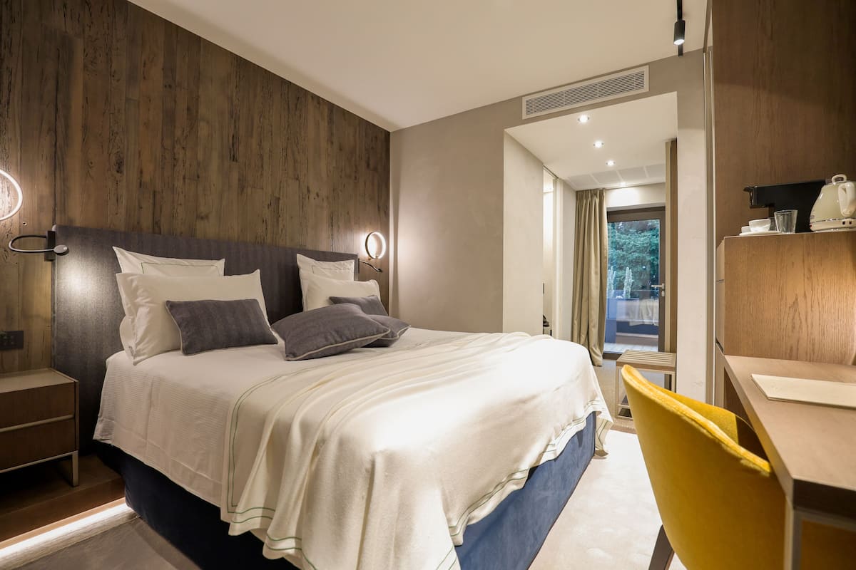 Habitació d'hotel moderna amb un llit gran, taules de nit, escriptori i una cadira.