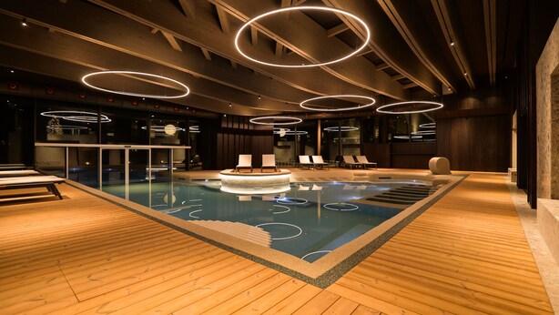 An indoor swimming pool with wooden flooring and circular light fixtures. - Collina Luxury Relais  (Clusone)