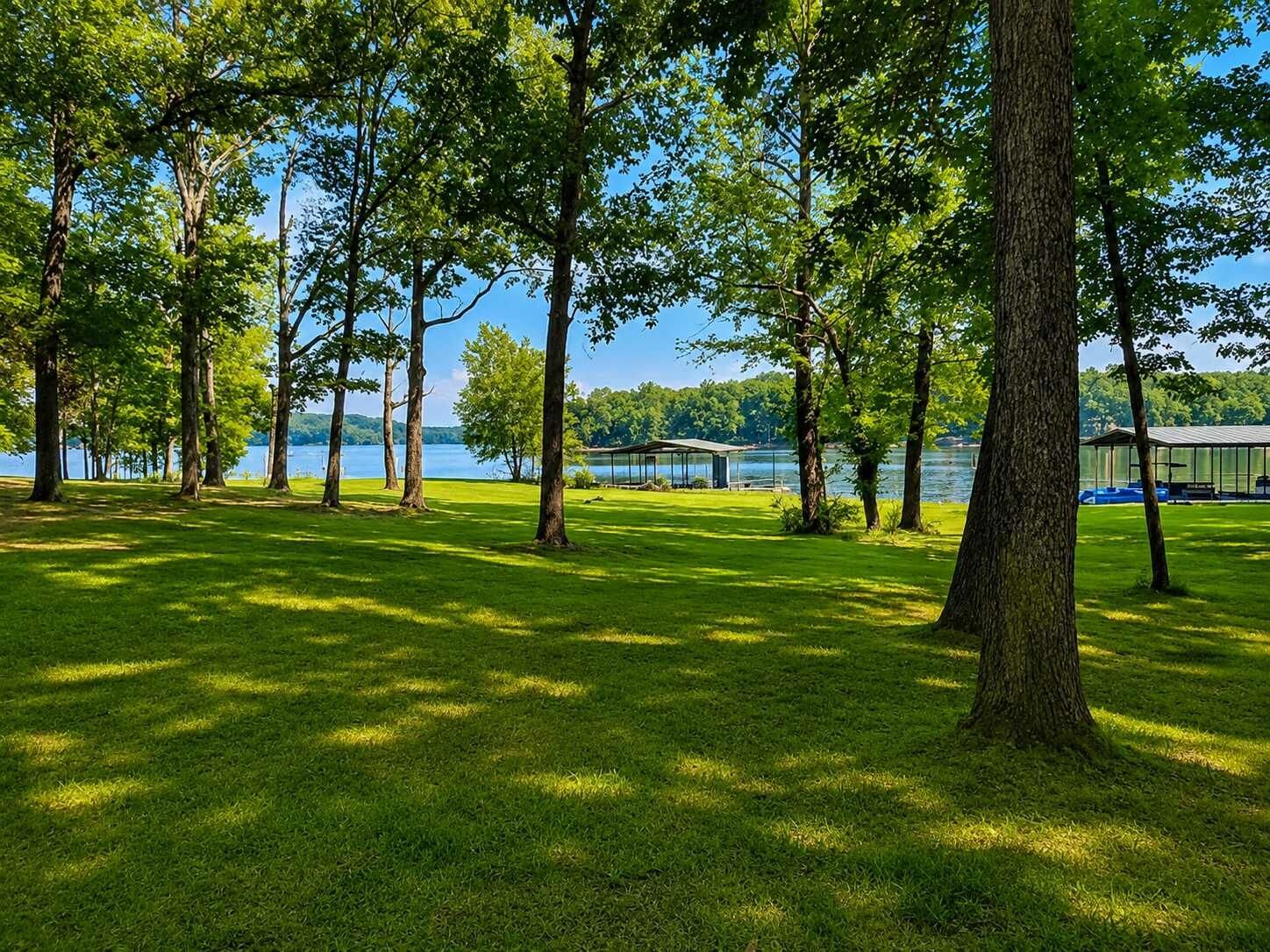 Ein Park mit Seeblick, Bäumen und einem überdachten Pavillon.