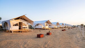 A row of white tents with a flat roof, arranged on a sandy beach. - Zostel Sam Desert (Jaisalmer) (Jaisalmer)
