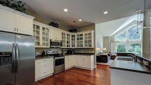 A modern kitchen with white cabinetry, stainless steel appliances, and a large window providing natural light. - 17 Cartgate - Palmetto Dunes - 4 Bed 4 Bath Private Pool -Hilton Head Rentals (Hilton Head Island)