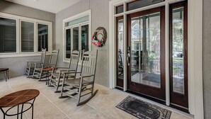 A spacious porch with multiple rocking chairs and a bench, large windows with shutters, and a welcome wreath. - 17 Cartgate - Palmetto Dunes - 4 Bed 4 Bath Private Pool -Hilton Head Rentals (Hilton Head Island)