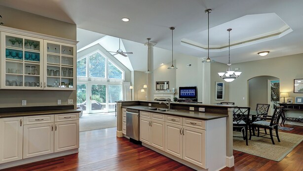 A spacious kitchen with a large island, white cabinetry, and a dining area with a chandelier. - 17 Cartgate - Palmetto Dunes - 4 Bed 4 Bath Private Pool -Hilton Head Rentals (Hilton Head Island)