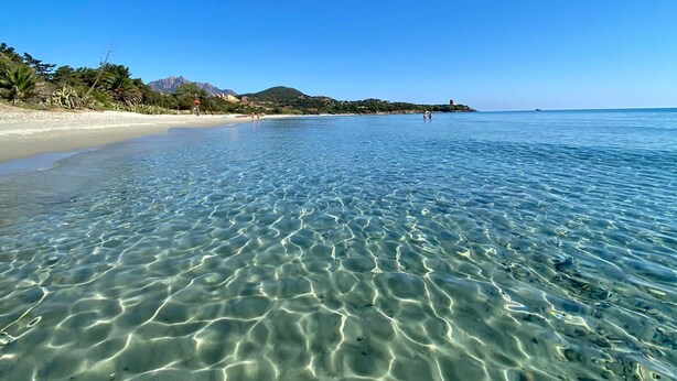 A clear beach with shallow water, a sandy shore, and a distant mountain range. - Detached villa within walking distance of Foxi and Murdegu beach (Foxi Murdegu)