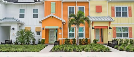 A playful blend of pastel and vibrant hues brings these Margaritaville inspired homes to life, framed by palms and greenery.