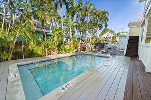 A swimming pool with a 4 FT depth limit, surrounded by palm trees and wooden deck. - Bahama Village studio @ the Galleria! (Key West)