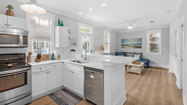A modern kitchen with white cabinetry, stainless steel appliances, and a central island. - Renovated 30A Bungalow 5 Min Walk to Beach!! (Santa Rosa Beach)