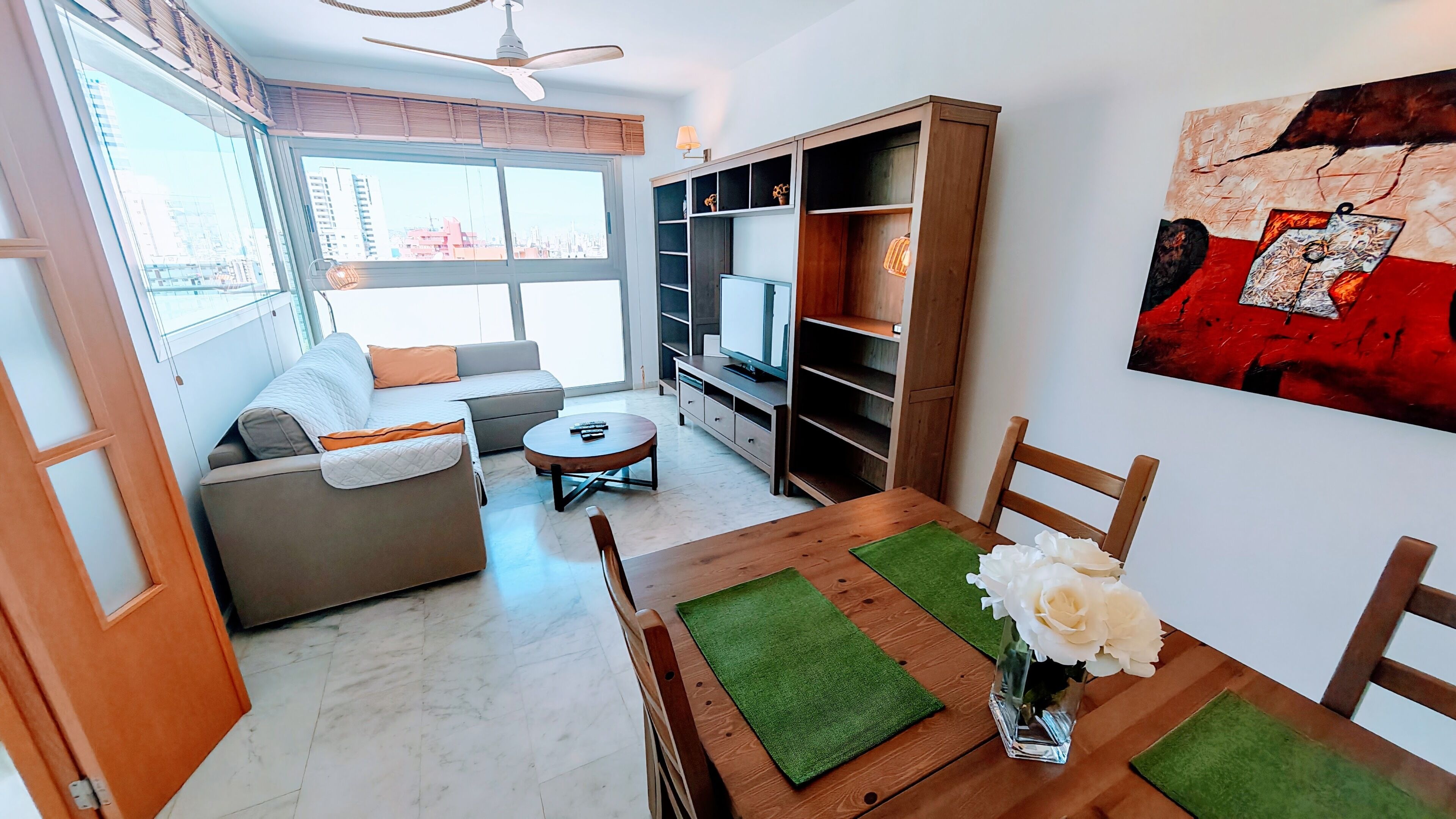 A living room with a sofa, coffee table, TV, and bookshelf.