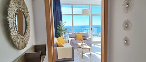 Una sala de estar moderna con un sofá, una mesa de centro y decoración en la pared.
