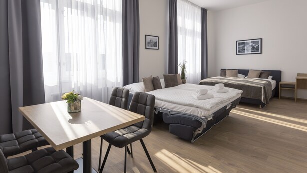 Habitació d'hotel moderna amb un llit, un escriptori i una cadira.