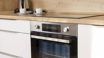 A modern kitchen with a built-in oven and a coffee maker on the countertop.