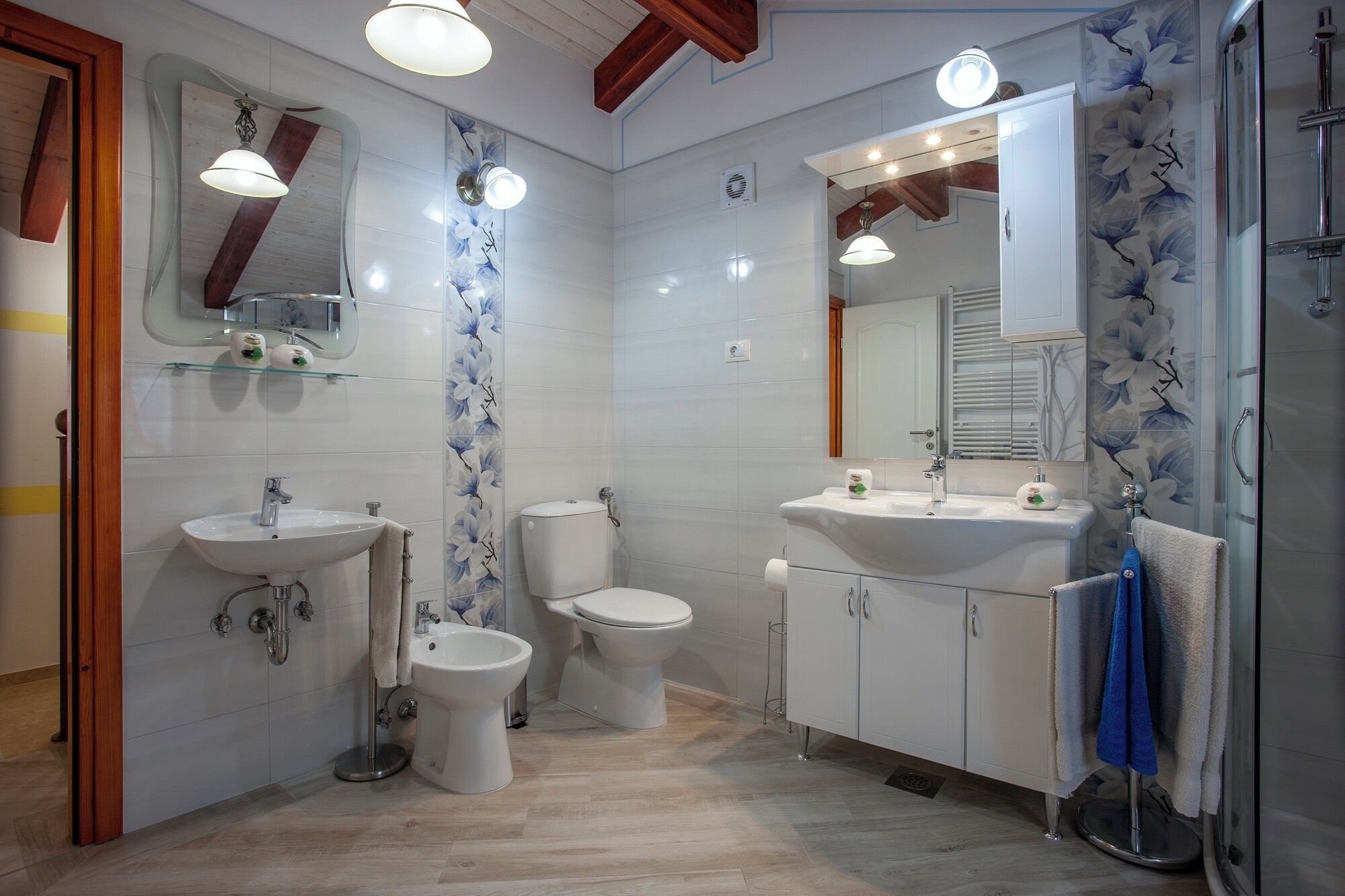 A modern bathroom with two sinks, a bidet, and a toilet.