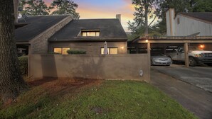 A residential house with a garage, a driveway, and a tree in the foreground. - Centrally Located 4br Stonecrest Condo 4 Bedroom Condo by RedAwning (Lithonia)