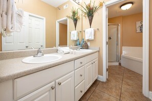 Bathroom features a double sink vanity, mirror, and shower area.