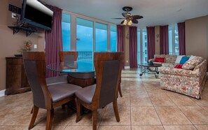 Relax in this inviting living area with a large dining table, comfortable sofa, and ocean views.