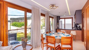 Un comedor moderno con una mesa redonda, sillas de madera y vistas al exterior.