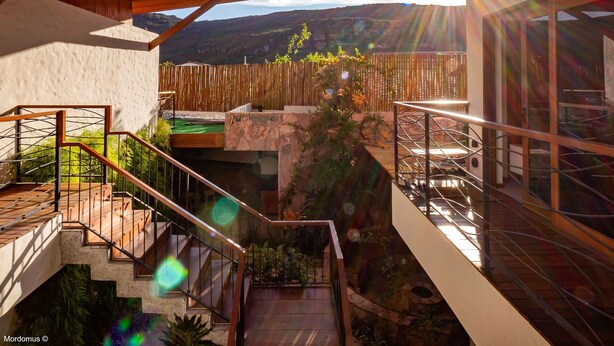 Una escalera exterior moderna con vistas a un paisaje montañoso.