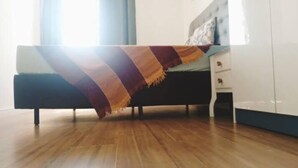 Un dormitorio con cama, mesita de noche y armario.