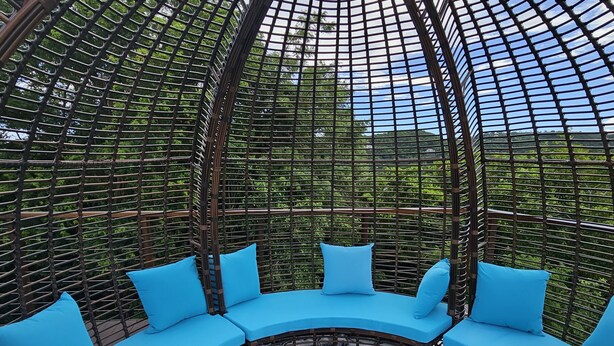Un espacio de estar al aire libre con cojines azules y un tapete estampado.