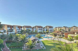 A resort with multiple hotel buildings, a central pool area, and surrounding greenery.