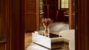 A room with a wooden floor, a white sofa, a small table with a vase, and a large window. - Exquisite Château de Thauvenay surrounded by Sancerre vineyards, 24 beds 23bath  (Thauvenay)