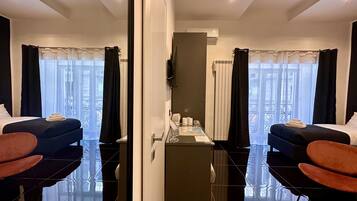 Ein Hotelzimmer mit einem großen Spiegel, zwei Betten, einem kleinen Tisch mit einer Karte und Blick auf den Balkon.
