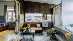 A modern living room with a sofa, a coffee table, and a view of the city through large windows. - Mây's House (Xuan Huong - Da Lat)