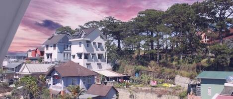 A residential area with houses, trees, and a hillside.