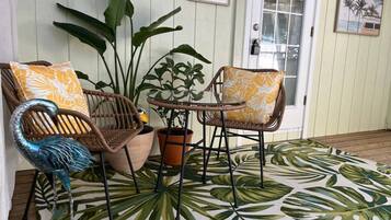 A seating area with wicker chairs and a potted plant.