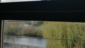 A view through a window with a stone wall and a river. - Stunning 2-bed Apartment in Carlow Town (Carlow)