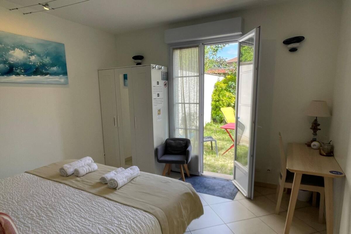 A bedroom with a bed, a wardrobe, a desk, and a chair.