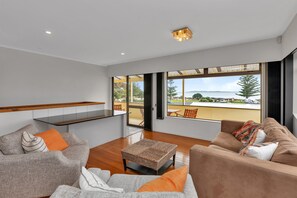 Una sala moderna con sofá, mesa de centro y vistas al exterior.