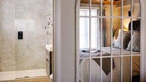 Une salle de bain moderne dotée d’une douche à parois de verre et d’un panneau de commande visible.