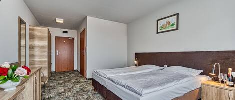 Quarto de hotel com cama, mesa de cabeceira e um quadro na parede.