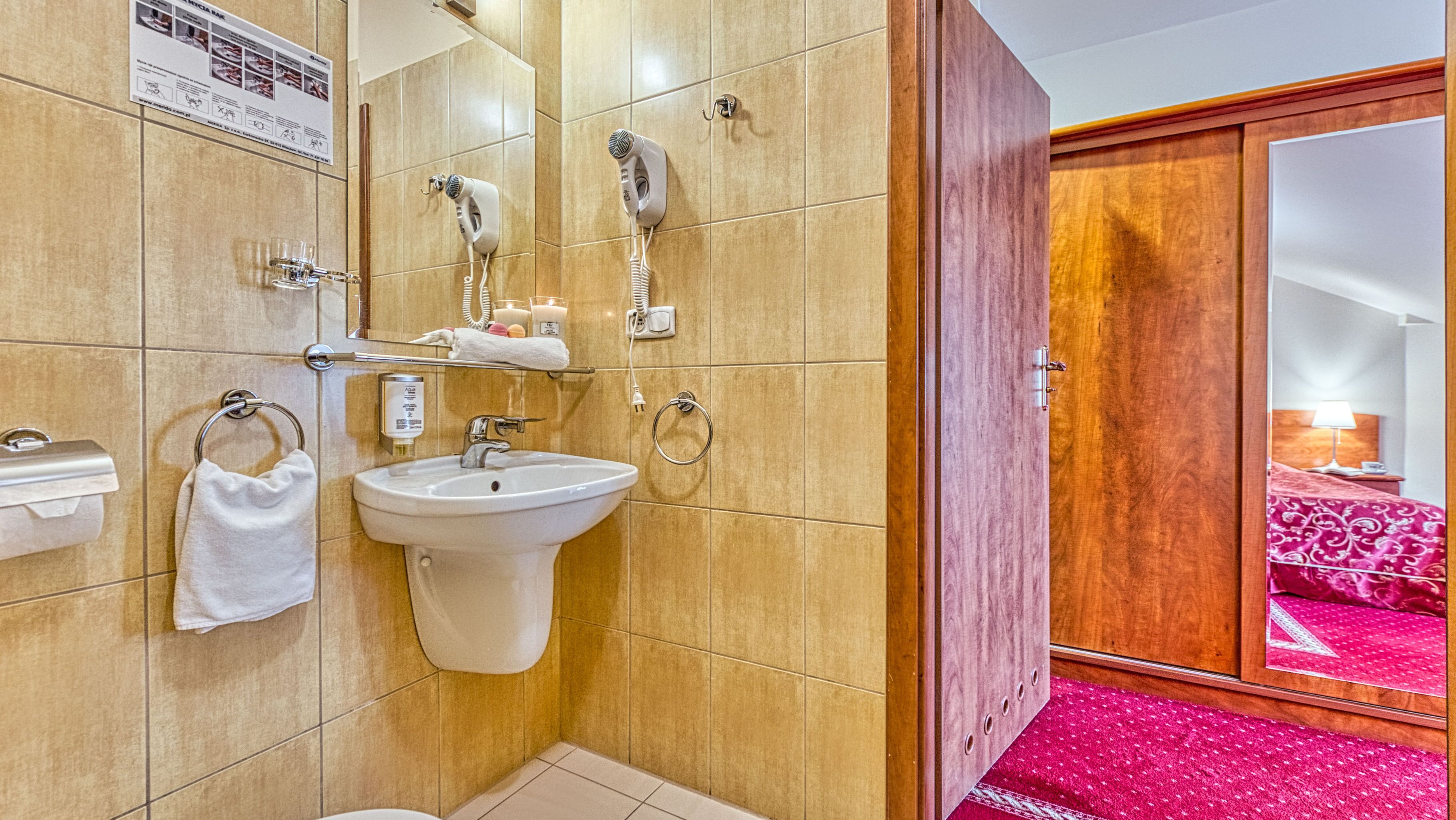 Un bagno con lavandino, portasciuga e asciugacapelli.