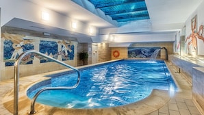 An indoor swimming pool with clear water, a tiled floor, and a mosaic wall depicting aquatic scenes. - St. Lukas Medical & SPA (Swieradow-Zdroj)