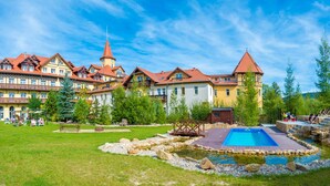 A hotel with multiple buildings, a swimming pool, and a small pond. - St. Lukas Medical & SPA (Swieradow-Zdroj)